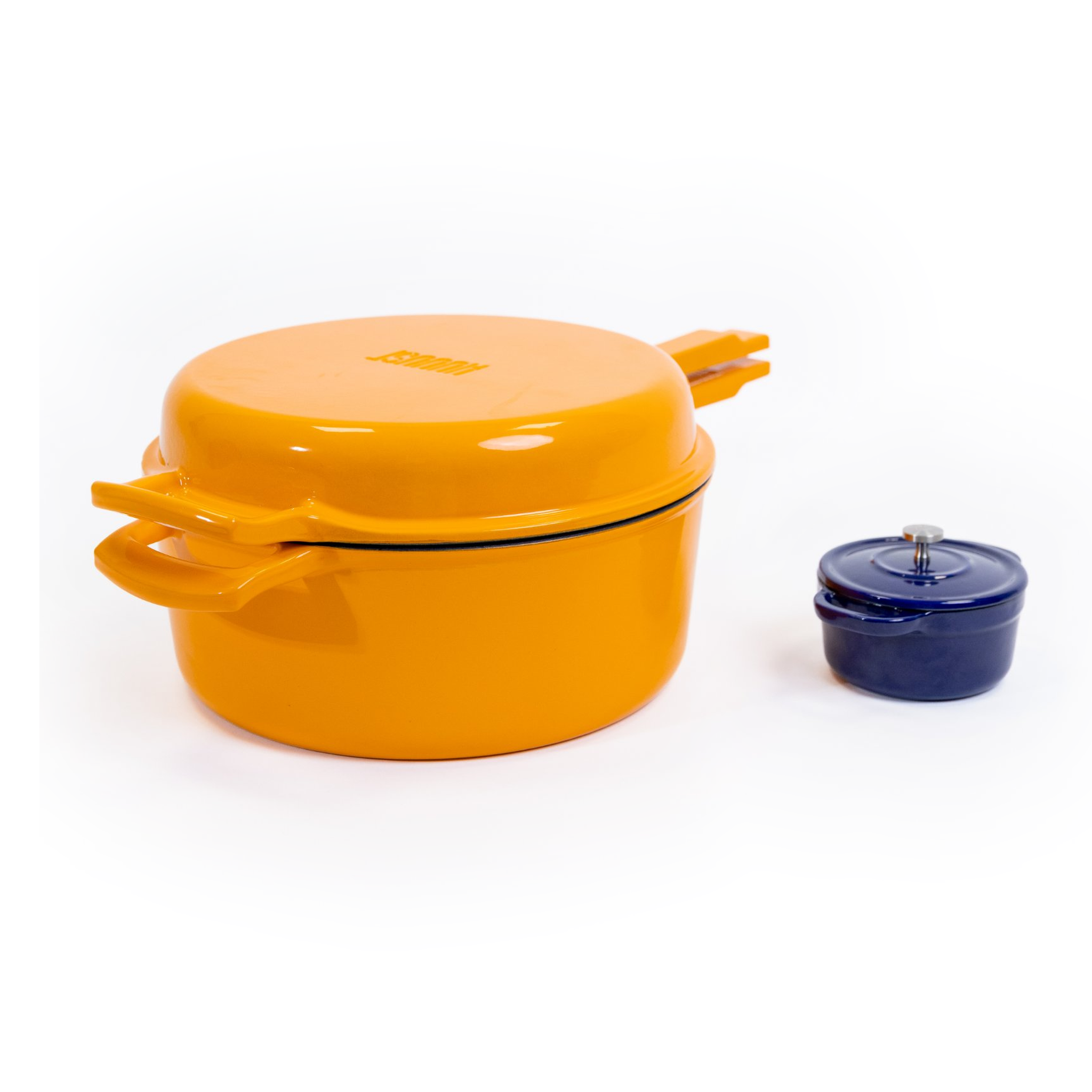 Oranžové HUUUST Combo 26 cm vedle modrého mini litinového hrnečku Ø 10 cm pro srovnání velikosti